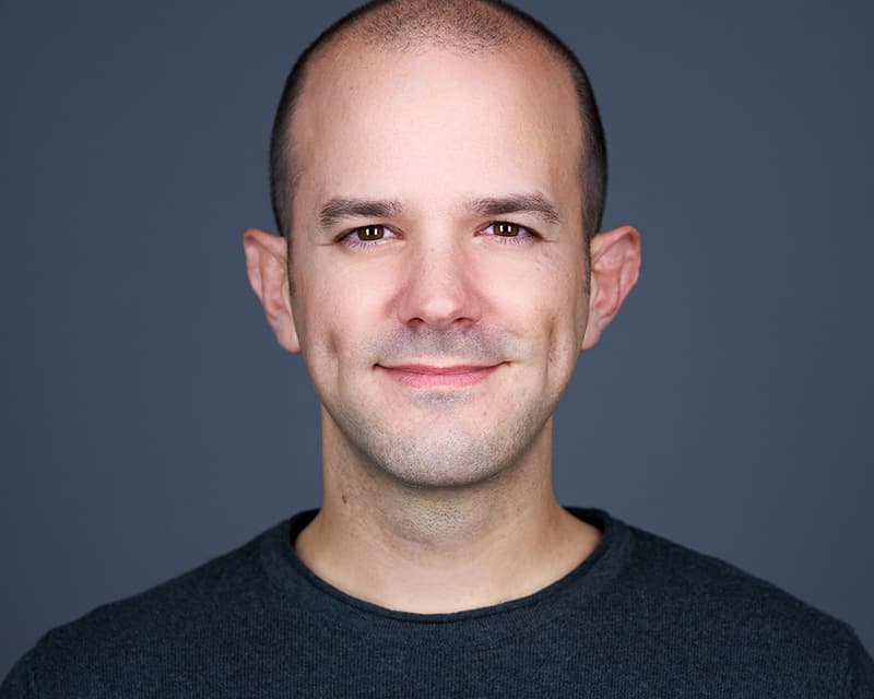 Headshot profissional com fundo cinza escuro